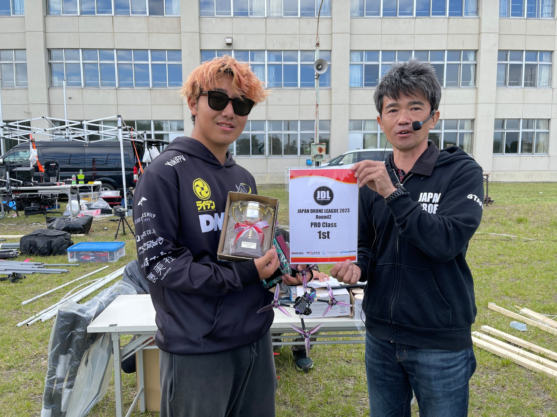 二連覇達成！ドローンレースチーム『RAIDEN RACING』高校生レーサー、橋本 勇希が『Japan Drone League 2023 Round 2 in チュプチニカ』で優勝！のサブ画像2_左：プロクラスで二連覇を達成したYUKI FPV、右：JDL共同代表理事 高橋 亨氏 @JDL